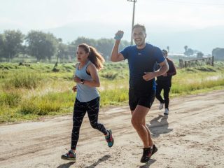 A group of runners enjoys a vibrant morning jog on a rural dirt road.